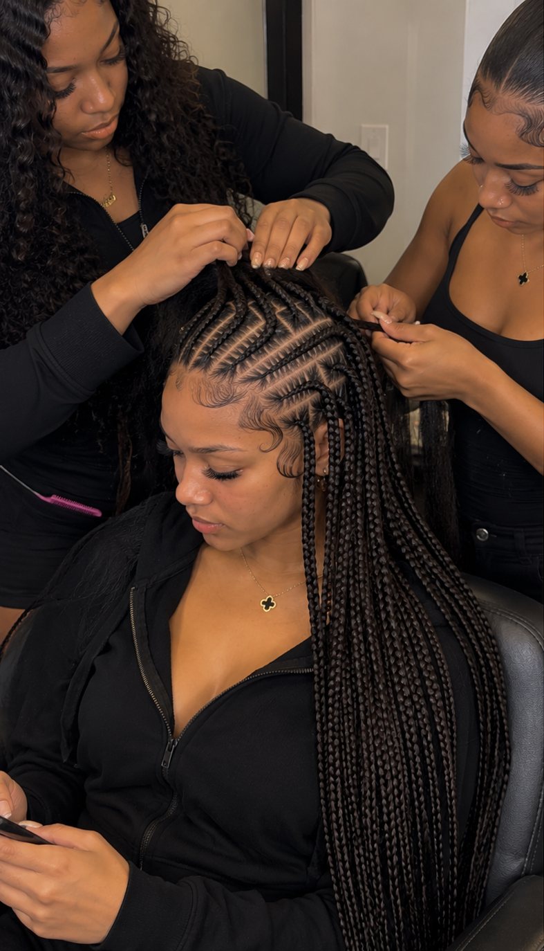 Two LI Queens stylists braiding a client's hair at the same time